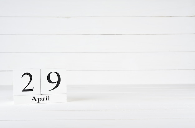 April 29th, Day 29 of month, Birthday, Anniversary, wooden block calendar on white wooden background with copy space for text.