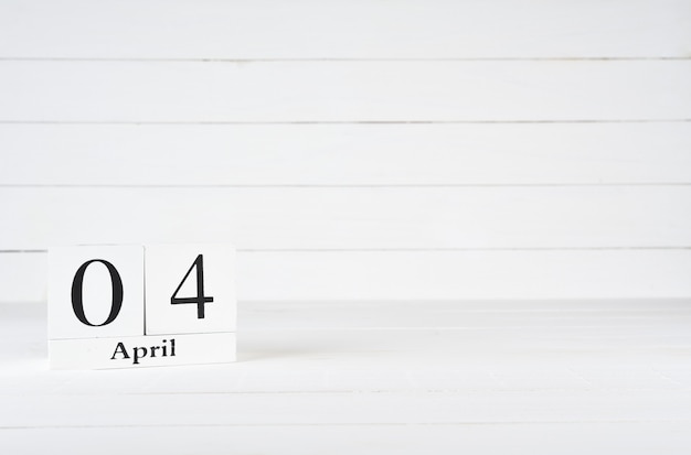 写真 4月4日、月の4日目、誕生日、記念日、テキスト用のコピースペースを持つ白い木製の背景に木製のブロックカレンダー。