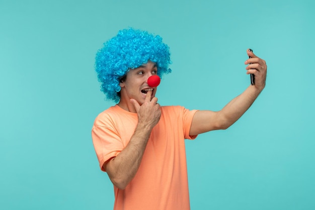 April dwazen dag kerel clown glimlachen bijten vinger blauw haar video-oproep telefoon selfie grappig rode neus