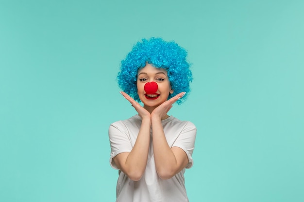 April dwazen dag lachend meisje hand in hand onder de kin met rode neus in een clown kostuum blauw haar