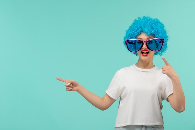 День дурака, клоун, улыбающаяся девушка, указывающая пальцем влево, большие синие солнцезащитные очки, смешной костюм, синие волосы