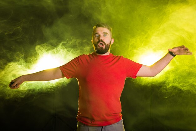 April fools day concept - Evil crazy young man making funny faces on smoky background.