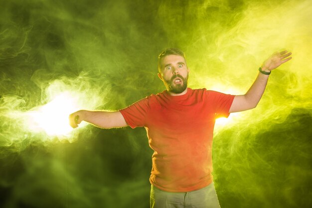 April fools day concept - Evil crazy young man making funny faces on smoky background.