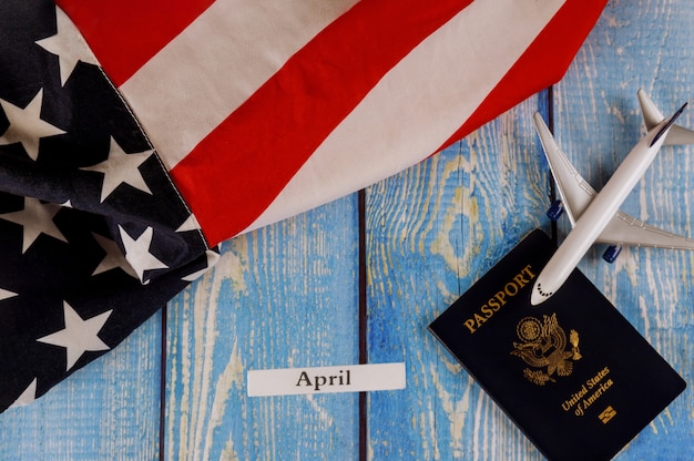 April maand van kalenderjaar, reizen toerisme, emigratie de Amerikaanse vlag met Amerikaanse paspoort en passagiersvliegtuig modelvliegtuig