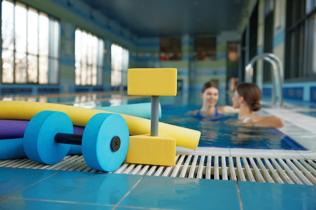 Aqua aerobics class gymnastics training lesson at health club with swimming pool