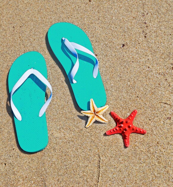 Photo aqua flip flops and starfish by the sea