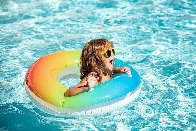 Aquapark summer vacation Boy in swiming pool Happy kid on inflatable rubber circle