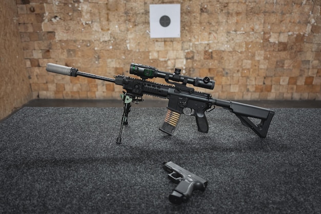 Пистолет AR-15 с цифровым прицелом ночного видения и пистолет на столе на стрельбище