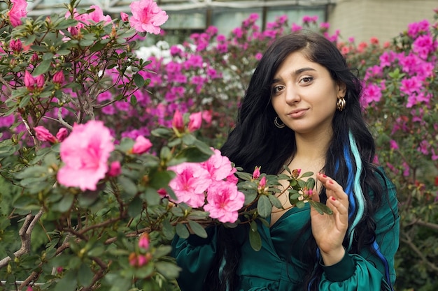 Arab brunette woman enjoying blooming garden. High quality photo