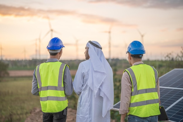 Арабский бизнес и инженер проверяют строительство панели солнечных батарей или фотоэлектрических элементов с помощью электронного устройства. Промышленная возобновляемая энергия зеленой энергии.