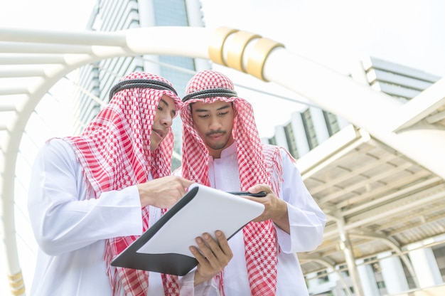 Uomo d'affari arabo che discute con il lavoro di ufficio e lo smart phone.