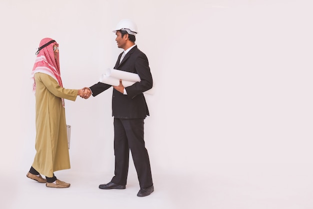 Handshaking arabo dell'operaio del caporeparto e dell'uomo d'affari