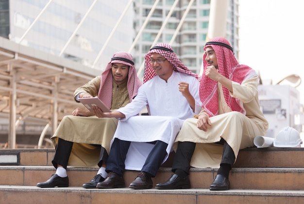 Uomo d'affari arabo accatastamento mani la loro squadra di lavoro con il concetto di successo.