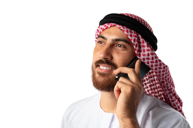 흰색 배경에 고립 된 휴대 전화에 얘기 하는 아랍 사업가