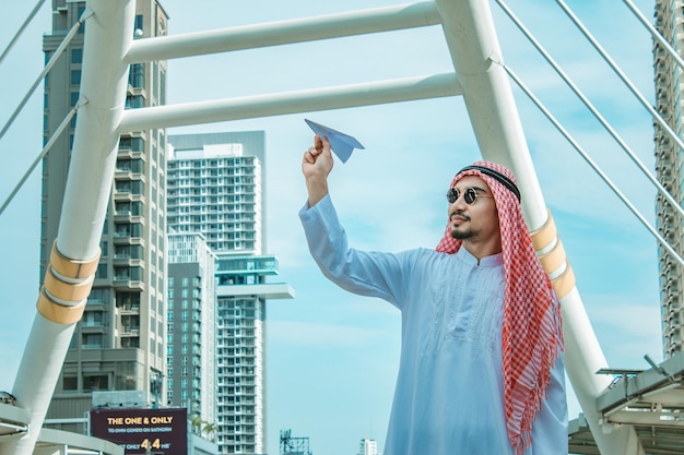 Arab businessman with paper airplane Cheerful Arab businessman holding an airplane