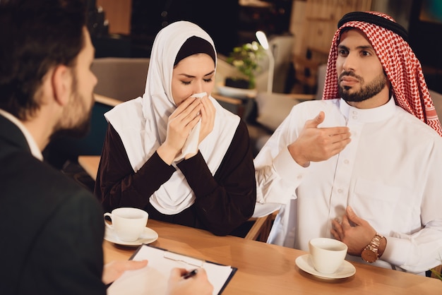 Arab couple drinks coffee at therapist reception.