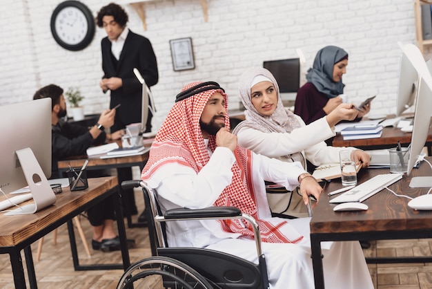 L'uomo e la donna disabili arabi discutono in ufficio.