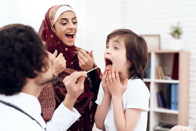 Un medico arabo diagnostica un bambino piccolo.