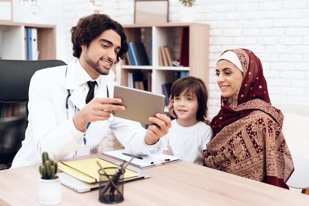 Arab doctor shows something on the tablet.