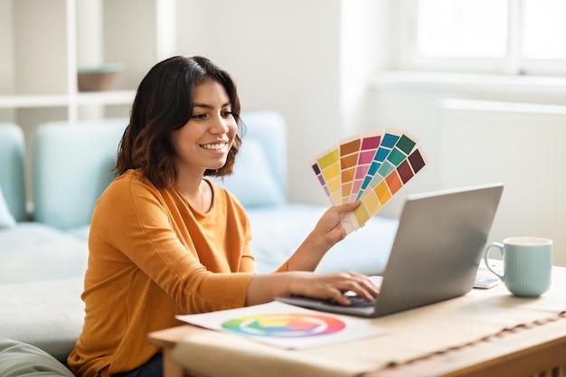 Arab Female Freelance Graphic Designer Working With Laptop And Color Swatches