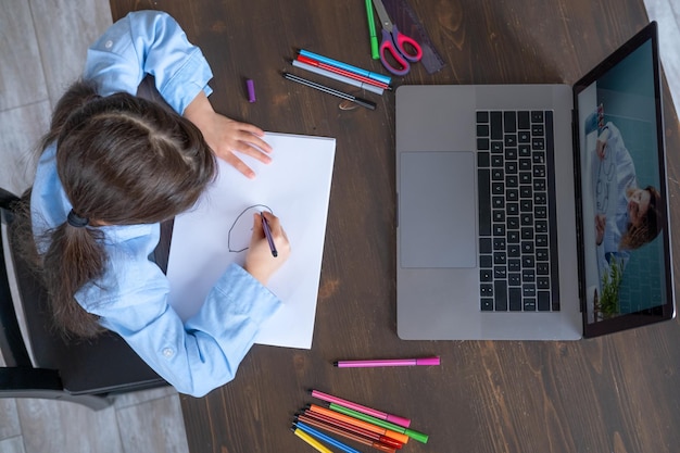 arab girl having online lesson education using laptop kid learning to draw with teacher online