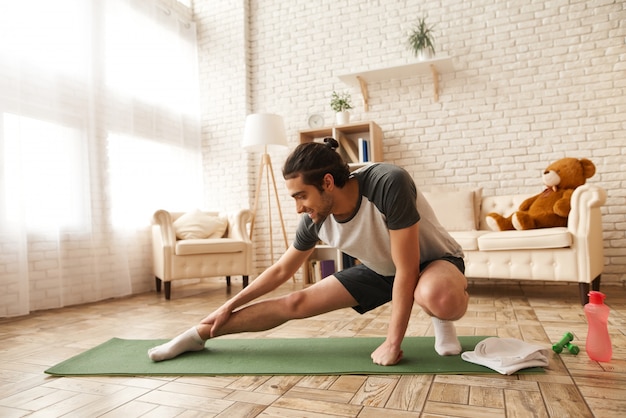 Arab Guy Does Stretching Exercise On Gym Carpet.