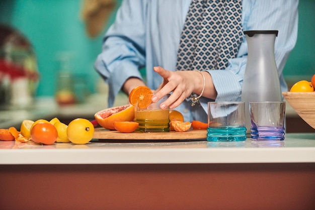 モダンなキッチンでフルーツジュースを作るアラブのヒジャーブの女性ホームコンセプト健康的なライフスタイルのコンセプトセレクティブフォーカス高品質の写真