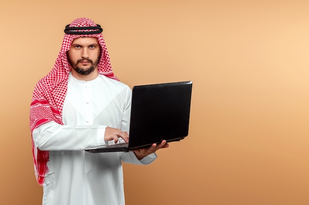 An Arab man, a businessman, a sheikh works at a laptop. Investments, business, work via the Internet, online contracts.