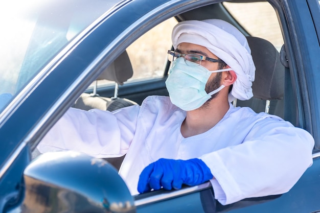 Арабский мужчина за рулем автомобиля во время пандемии