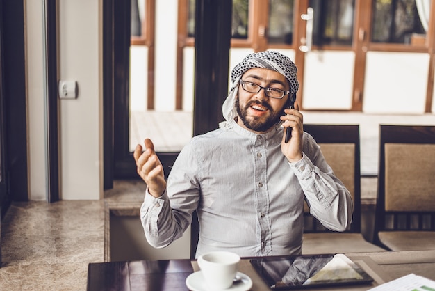 Arab man is drinking coffee in a cafe.