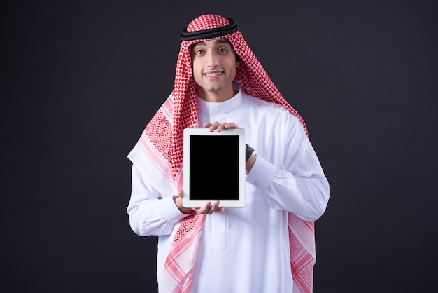 Photo arab man posing with black tablet isolated.