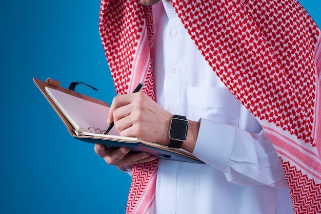 고립 된 노트북에 메모를 복용하는 아랍 사람.