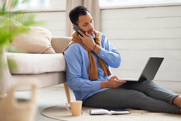 Arab man working and talking on phone at home