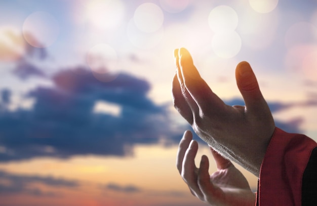 Arab Muslim man hands pray under sunrise light