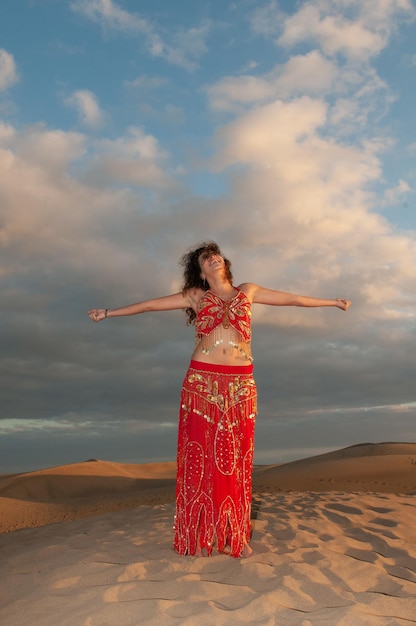 Photo arab woman in the desert dunes at sunset