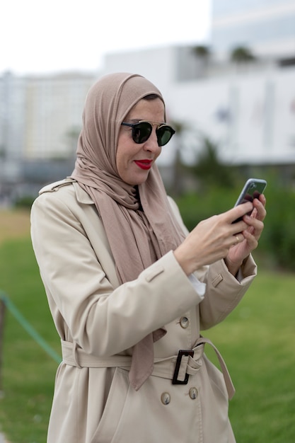 Foto donna araba con hijab parlando al telefono