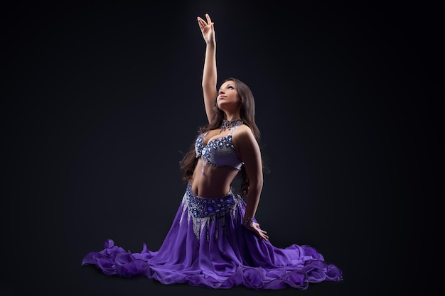 Arabia dancer posing in dark oriental costume