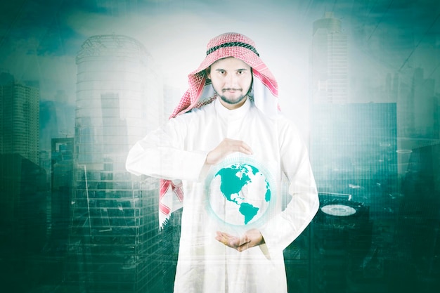 Arabian businessman holding a virtual globe