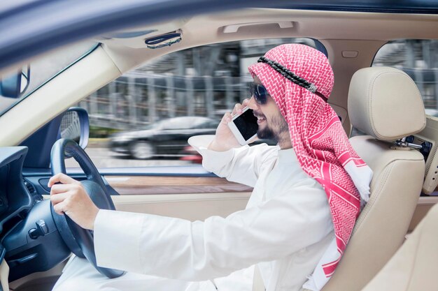 Arabian businessman talking on a phone in car