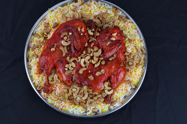 Foto piatto di riso mandi di pollo arabo con topping di anacardi