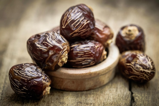 Arabian Dates in bowl on wooden surface