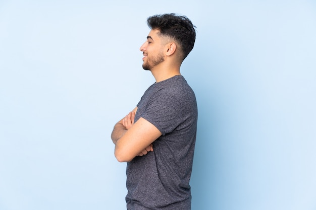 Arabian handsome man over isolated wall in lateral position