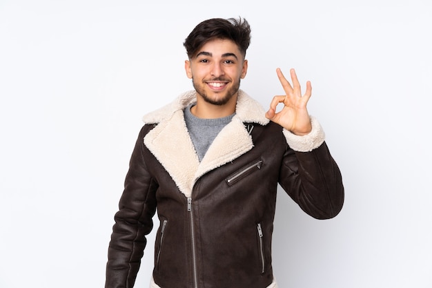 Arabian handsome man over isolated wall showing ok sign with fingers