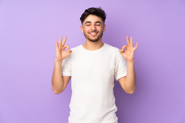 Arabian handsome man over isolated wall in zen pose