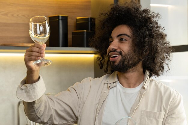 Photo arabian man checks stains on wineglasses after dishwasher