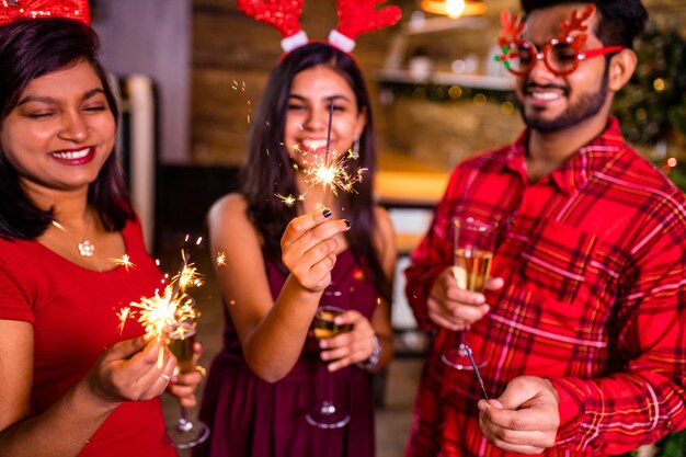 Arabian people celebrating Christmas or New Year eve party with Bengal lights ooking happy while having party on the kitchen at stay home quarantine corona virus outbreak party