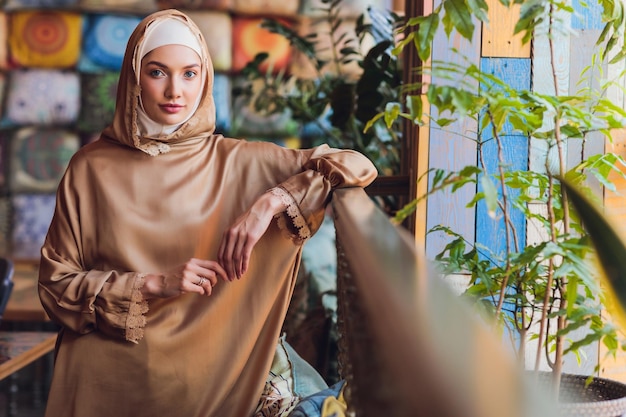 Foto giovane donna musulmana araba seduta in un caffè a