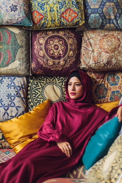 Арабская молодая мусульманская женщина, сидящая в кафе