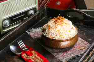 Photo arabic chicken biryani or meat biriyani with fried onion served in dish isolated on red mat top view on table arabic food