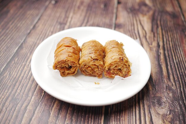 arabic dessert baklava on a plate on wooden table